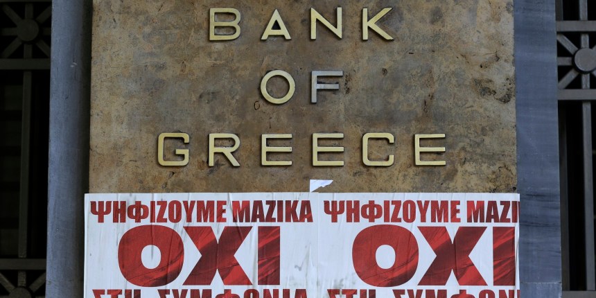 Posters reading "We vote en masse, no the agreement'' are seen under Bank of Greece logo in Athens, Friday, July 3, 2015. The brief but intense campaign in Greece's critical bailout referendum ends Friday, with simultaneous rallies in Athens supporting "yes" and "no" answers to a murky question in what an opinion poll suggests could be a very close vote.  (AP Photo/Thanassis Stavrakis)