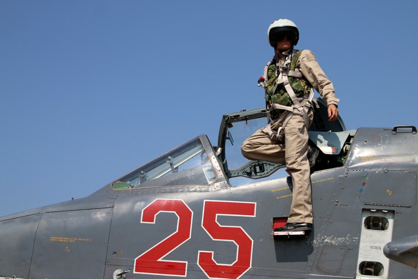 In this photo taken on Saturday, Oct. 3, 2015, Russian army pilot poses at a cockpit of SU-25M jet fighter at Hmeimim airbase in Syria. Russia has insisted that the airstrikes that began Wednesday are targeting the Islamic State group and al-Qaida's Syrian affiliates, but at least some of the strikes appear to have hit Western-backed rebel factions.(AP Photo/Alexander Kots, Komsomolskaya Pravda, Photo via AP)